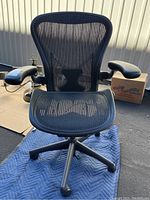 Front view of chair showing mesh seat, backrest and armrests