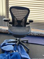 Front view of chair showing mesh back, seat and armrests