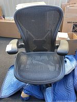 Front view showing full mesh back and seat with armrests and five-star base