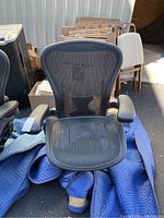 Front view of chair showing mesh seat and armrests