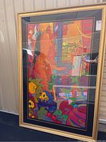 Full front view of the framed painting, showing colorful abstract interior scene and gold frame.