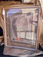 Framed limited edition signed artwork showing abstract textured design in grey tones with a city reflection on glass.