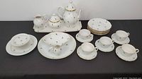 Overall view showing long platter, teapot, sugar bowl, creamer, sauce boat, large plate, side plates, teacups and saucers