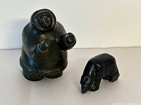 Photo showing both the Inuit human figure and bear stone sculptures side by side for size and condition comparison.