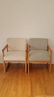 Both oak framed chairs side by side, beige on left and grey on right.