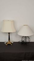 Pair of side table lamps shown together on a black fabric surface against a white background, showing different styles and sizes.