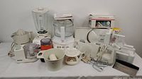 Front overview of all included appliances showing blender, food processors, hand mixer, juicer, meat slicer and scale.