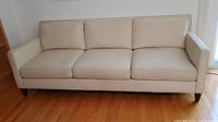 Front view of three-seat sofa showing full frame and cushions