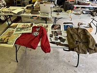 Overview of table with uniforms, windbreaker, prints and accessories