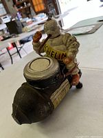 Cast iron bank showing Michelin Man figure on tire pump from front side