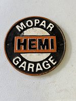 Front view of cast iron round sign showing Mopar Garage text and HEMI logo in center.