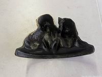 Top view of cast iron door stop showing sculpted dogs and overall shape.