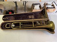 Full view of Old's Ambassador Model trombone inside its original hard case with purple velvet interior.