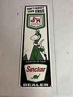 Full front view of porcelain sign showing S&H Green Stamps logo, cartoon dinosaur and Sinclair branding