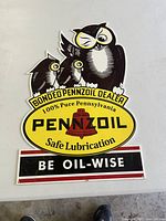Photo of vintage porcelain Pennzoil 'Be Oil-Wise' advertising sign featuring owls and brand logo