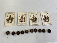 Four Boy Scouts of America cards showing scouting illustration and motto, laid out horizontally with eight matching Boy Scout emblem pin backs below them.