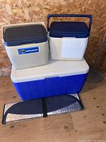 All coolers and sun shield arranged together on wooden floor against wooden wall