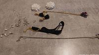 Lay out showing all items: black velvet choker with gold chain, white pearl drop earrings, white flower stud earrings, silver-tone loop earrings, gold and silver chain necklaces, and gold-tone shoe clips with velvet and floral detail.