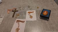 Top view of entire lot showing crucifix pendants, medals, necklaces and cameo brooch in box