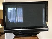 Front view of LG plasma TV powered off, showing reflective screen and LG logo on bezel.