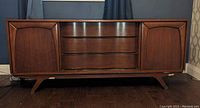 Front view with doors closed showing center bowed drawers and side doors