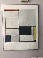 Framed abstract geometric art print by Piet Mondrian featuring colored rectangles and black grid lines.