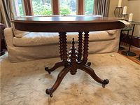 Full view of table showing oval top and turned pedestal base