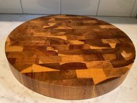 Top-down view showing the round shape and end-grain wood pattern of the cutting board.