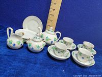 Full tea set including tea pot, sugar bowl, creamer, four cups and saucers with ruler for scale