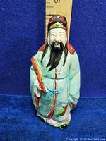 Front view of the vintage Fu Lu Shou porcelain figurine with detailed facial features and colorful traditional attire.