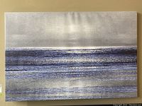 Front view of the stretched canvas print showing the ocean scene with layered blue and gray waves under a gray sky.