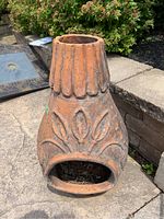 Front view showing soot inside opening and stylized leaf design on the body of the chimenea.