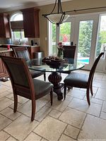 Full view of glass top table and four chairs in kitchen setting