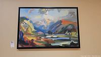 Full view of the framed colorful abstract landscape print with label on the left wall.