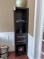 Full view of the tall dark finished MDF shelving unit with two drawers and open shelves.