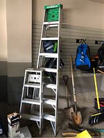 Both Featherlite aluminum step ladders together showing size difference and overall condition.