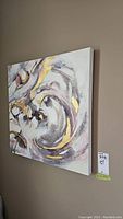 Side view of the square stretched canvas wall art hanging on a wall, showing abstract design and gold leaf highlights.