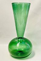 Front view of green blown glass trumpet vase showing spherical base and textured bubble pattern