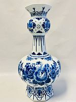 Front view of the blue and white hand painted porcelain vase showing detailed floral designs on white background.