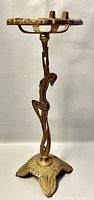 Full view of the standing ashtray showing the dancing lady figure as the main support and decorative base.