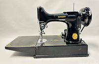 Side profile of Singer 221-1 Featherweight sewing machine mounted on base