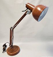 Full view of the vintage adjustable desk lamp showing the brown metal shade, wooden base, adjustable arm, power cord, and switch.