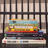 Stack of 10 kids books including Tyrannosaurus Wrecks, Diary of an 8-Bit Warrior, Diary of a Wimpy Kid Wrecking Ball, Almanac 2021, Teen Titans Earth One, Green Lantern New Guardians, Discovery Kids Facttivity, and The LEGO Ideas Book