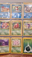Photo of nine Pokémon cards in binder showing Krabby, Magikarp, Staryu, Parasect, Koga's Koffing and others.