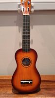 Front view of the ukulele showing sunburst finish and fretboard.
