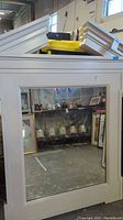 Full front view of one large mirror showing white frame and reflective glass