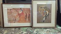 Two framed Native American artworks side by side on a surface, showing their full appearance with wooden frames and glass.