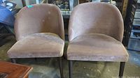 Two brown Ultrasuede occasional chairs set side by side showing wear and stains on seats and backs.