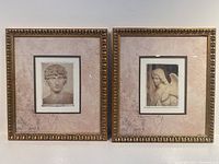 Photo of both framed prints side by side on white wall showing classical-style busts with gold decorative frames and beige mattes.