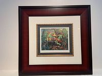 Framed limited edition print titled 'The Tangled Garden' by J.E.H MacDonald, showing whole framed artwork hung on a wall.